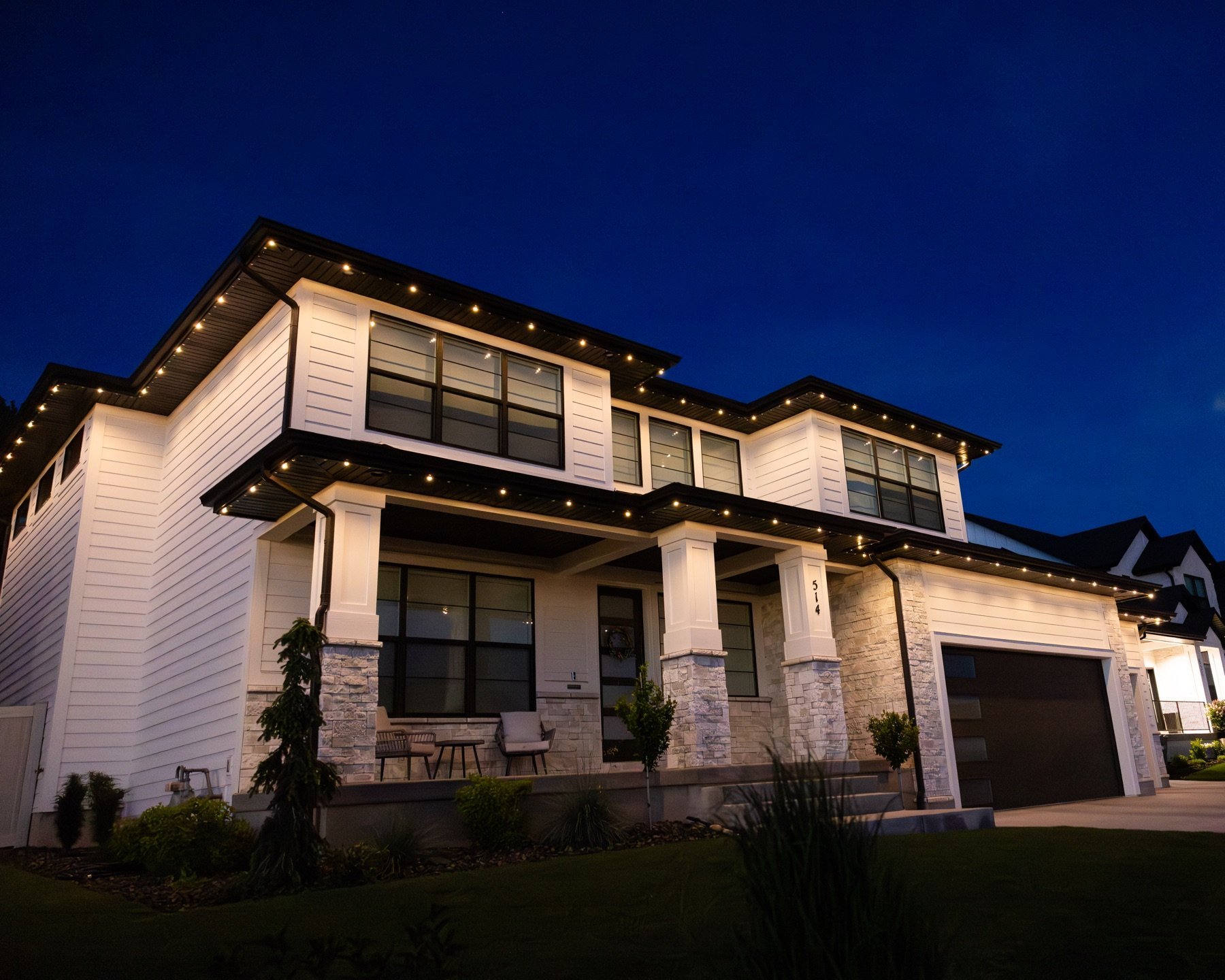 Warm roofline accents on a two-story home at dusk