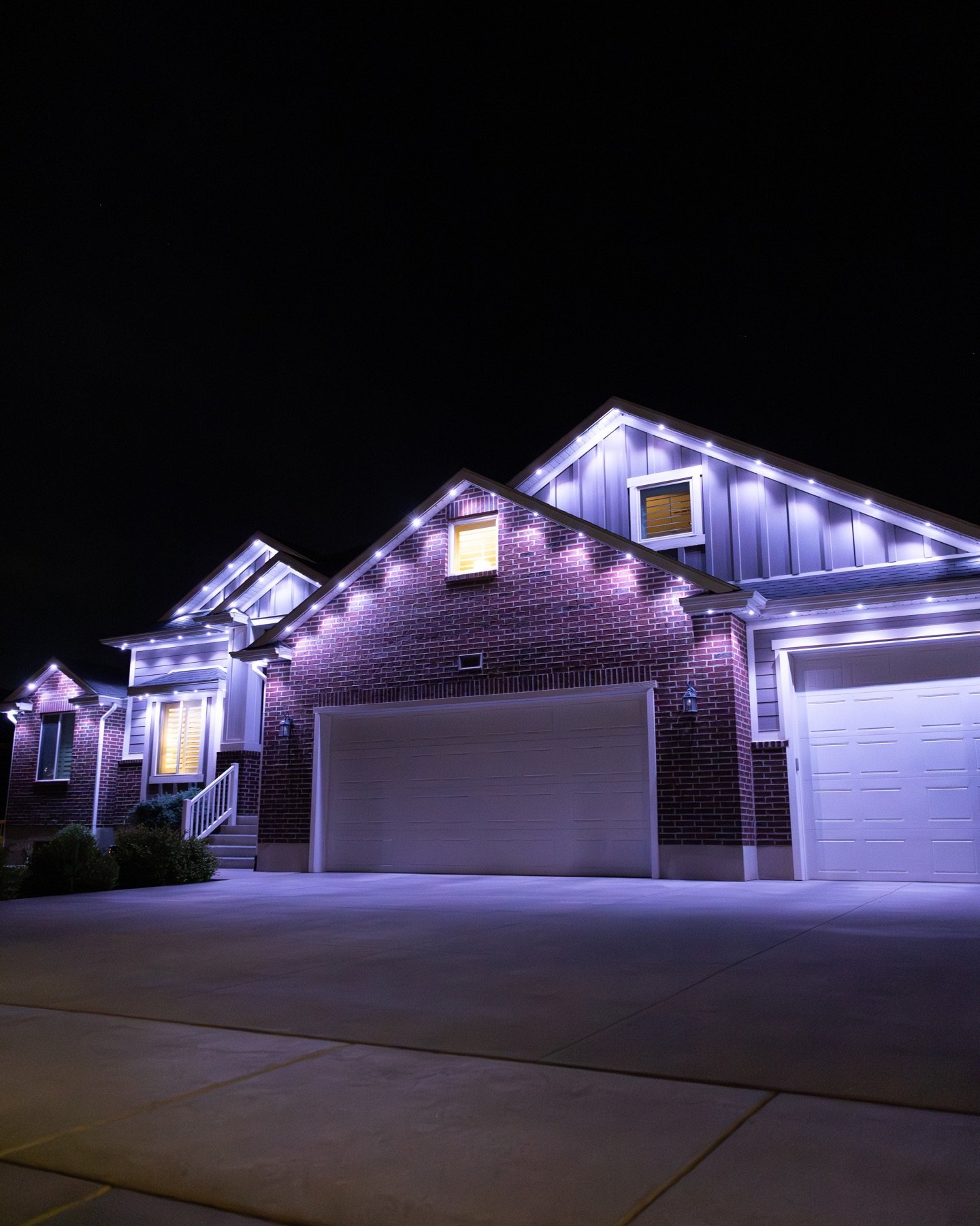 Soft white roofline lighting above a garage at night