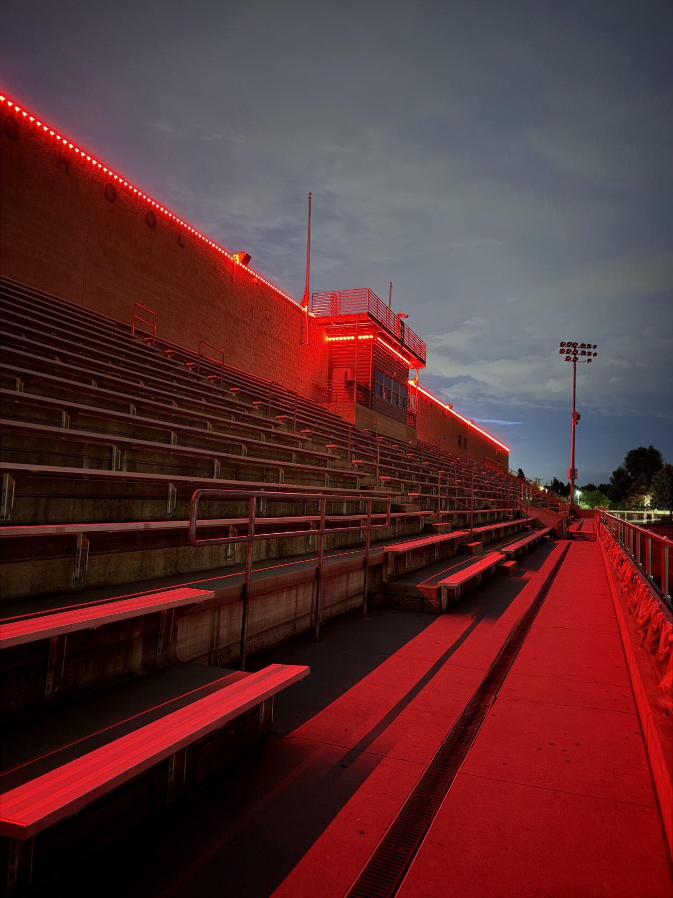 Red lighting along the roof above stadium seating