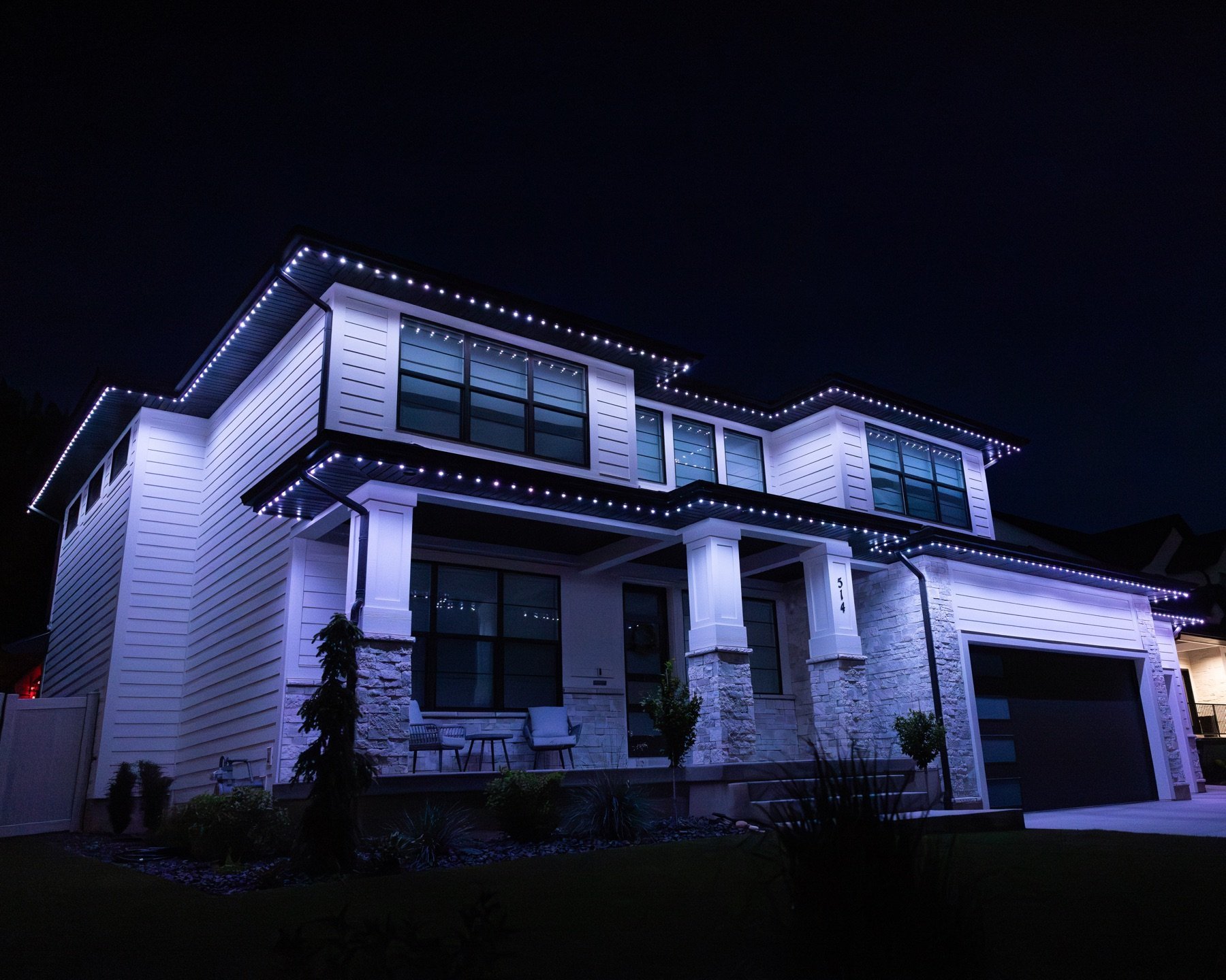 White lights outlining a two-story home at night
