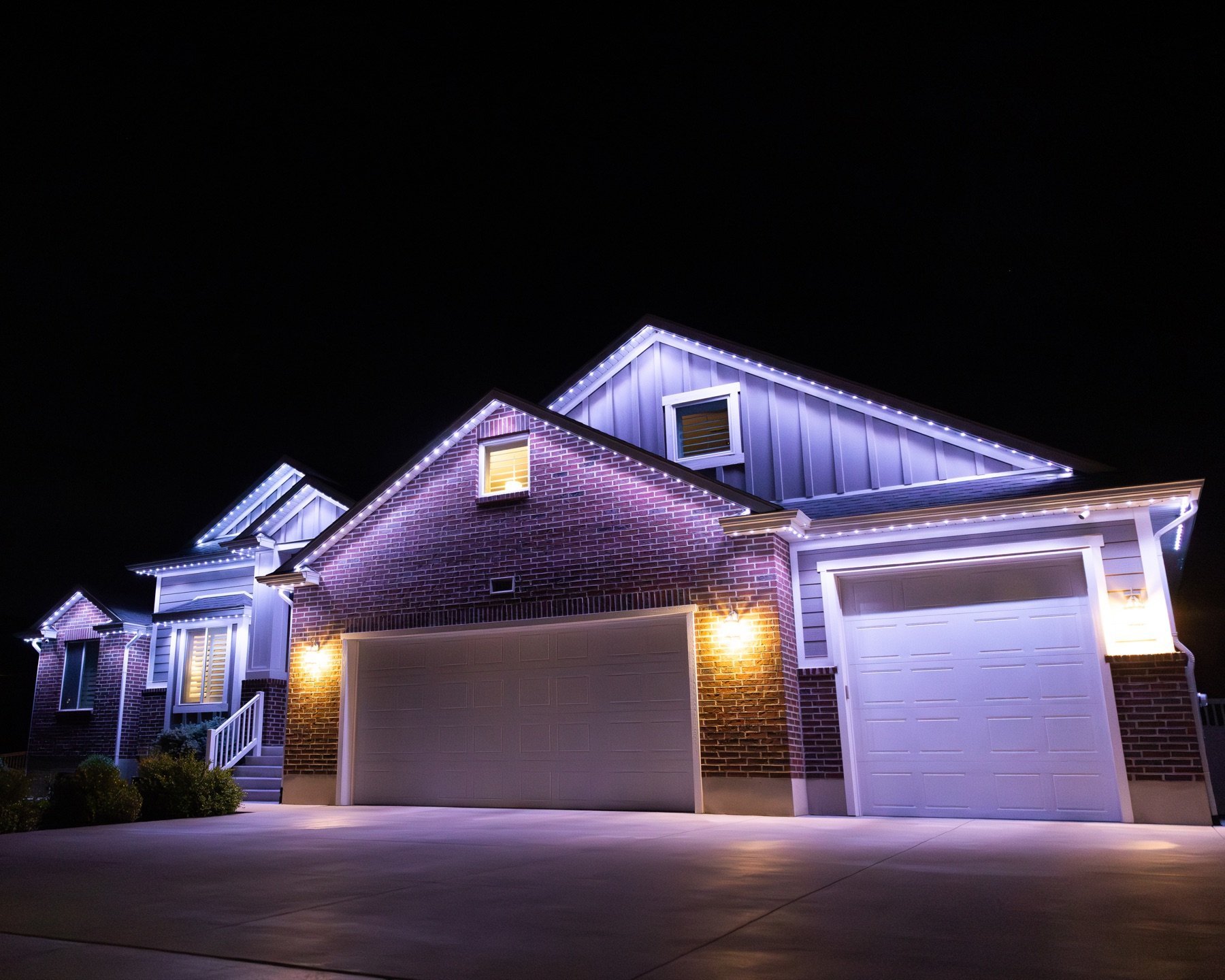 White roofline lights illuminating a driveway and garage